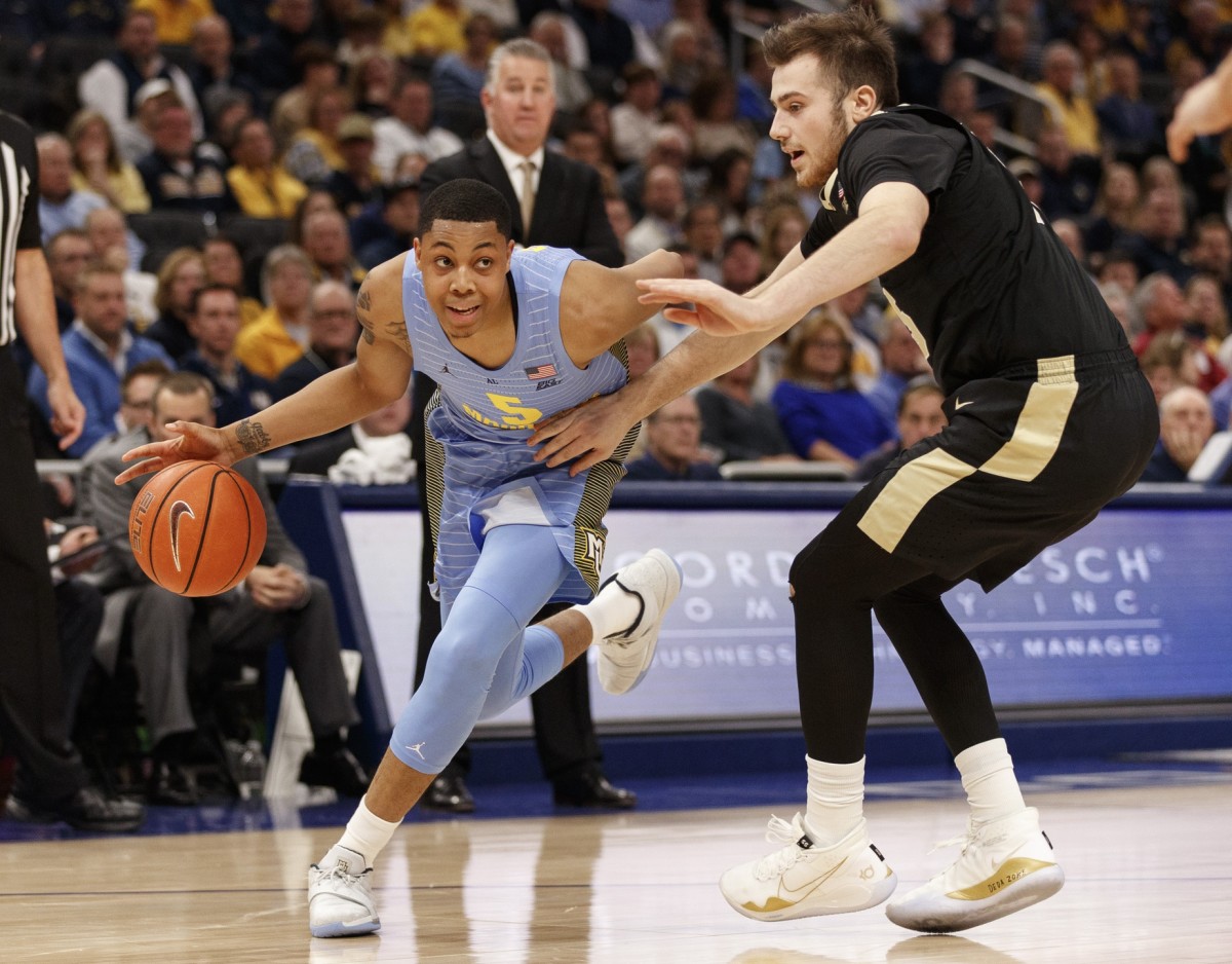 Marquette Golden Eagles guard Greg Elliott (5) drives for the basket around Purdue Boilermakers guard Sasha Stefanovic (55) during the first half at Fiserv Forum in Milwaukee, Wisconsin (2019). 